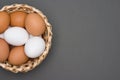 White and brown eggs in the basket on a gray table. Easter. Top view Royalty Free Stock Photo