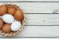 White and brown eggs in the basket on the table. Easter. Top view Royalty Free Stock Photo