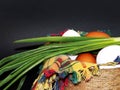 White and brown eggs and a bunch of green onions on a checkered napkin in a bowl on a black background Royalty Free Stock Photo