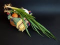 White and brown eggs and a bunch of green onions on a checkered napkin in a bowl on a black background Royalty Free Stock Photo