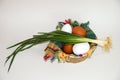 White and brown eggs and a bunch of green onions on a checkered napkin in a bowl on a white background Royalty Free Stock Photo