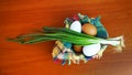 White and brown eggs and a bunch of green onions on a checkered napkin in a bowl on a wooden table Royalty Free Stock Photo