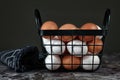 White and brown eggs inside of back metal egg basket