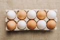 white and brown eggs laying in egg carton on sackcloth Royalty Free Stock Photo