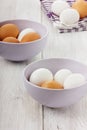 White and brown eggs in a lilac ceramic cup