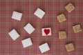 White and brown sugar cubes with a red heart on one of them. Top view. Diet unhealty sweet addiction concept Royalty Free Stock Photo