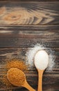 White and brown sugar in spoon on brown background Royalty Free Stock Photo