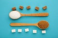 White and brown sugar in wood spoon on blue background Royalty Free Stock Photo