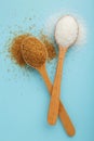 White and brown sugar in wood spoon on blue background Royalty Free Stock Photo