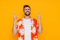 White brunette man wearing shirt holding fingers for best luck