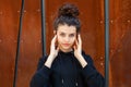 White brunette teenage girl with curly hair poses on the street in the city.