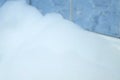 White bubbled foam in bathroom on blue tile background.