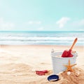 White bucket with red shovel and rake on beach Royalty Free Stock Photo