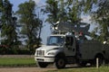 White Bucket truck for tree trimming in Kansas with blue sky and tree`s and white clouds.