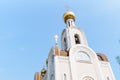 A white Orthodox church with golden domes against the background of a blue sky. Royalty Free Stock Photo