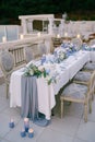 White bunk wedding cake decorated with flowers stands on a table with burning candles Royalty Free Stock Photo