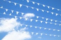 White bunting pennant triangle flags hanging on rope line in many rows