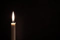 White burning candle on a black background. Mourning, burning candle Royalty Free Stock Photo