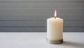 White burning candle white table. Gray backdrop Royalty Free Stock Photo