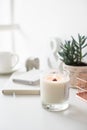 White burning candle on table, home interior decorations Royalty Free Stock Photo