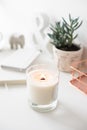 White burning candle on table, home interior decorations Royalty Free Stock Photo