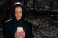 White burning Candle in woman`s hands in the middle of the forest. Hope and Pray concept. All Saints Day celebration. Witchcraft Royalty Free Stock Photo