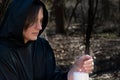 White burning Candle in woman`s hands in the middle of the forest. Hope and Pray concept. All Saints Day celebration. Witchcraft Royalty Free Stock Photo