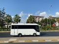 White bus and beautiful modern buildings, architecture, road and palm trees in a warm tropical oriental southern country resort