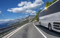 A white bus rides along the highway against the backdrop of a beautiful landscape Royalty Free Stock Photo