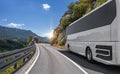 A white bus rides along the highway against the backdrop of a beautiful landscape Royalty Free Stock Photo