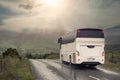 White bus on a small narrow country road. Mountains in a fog in the background. Transportation in rural area. Dramatic nature Royalty Free Stock Photo