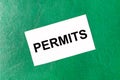 White business card with the text PERMITS on a dark green background Royalty Free Stock Photo