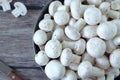 White button champignon mushrooms (agaricus bisporus) in a bowl with knife on wooden table, top view Royalty Free Stock Photo