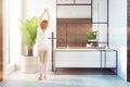 White cabinets bathroom, sink and plant, woman