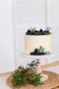 White cake with cream cheese and fresh blueberries and blackberries on white background. Confectionery, bakery concept. Close up.