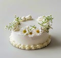 A white cake with daisies on top