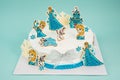 White cake with Elsa cake decorations isolated on the blue background