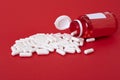 White calcium pills pouring out of red bottle Royalty Free Stock Photo