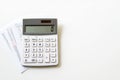 A white calculator and a crumpled piece of paper with handwritten notes isolated on white background Royalty Free Stock Photo