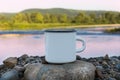 White campfire enamel mug mockup with sunrise river view Royalty Free Stock Photo