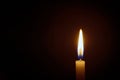 White candle flame closes upon a black background, Candle Burning in the Dark with lights glow, The burning candle`s flame with l Royalty Free Stock Photo