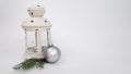 a white candle holder, a Christmas tree toy in the form of a silver frosted ball and a fir branch on a white background Royalty Free Stock Photo