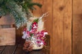 White candle holder decorated with pine cone and red ashberry under Christmas tree on wooden background Royalty Free Stock Photo