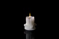 White candle lit burning on black background Royalty Free Stock Photo