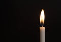 white candle lit in the dark with black background Royalty Free Stock Photo