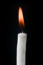 White candle lit with red and yellow flame Royalty Free Stock Photo