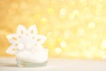 White candle and snowflake on golden bokeh background