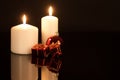 White candles with Christmas decorations against a black background Royalty Free Stock Photo