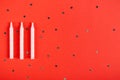 White candles composition on red background, party and celebration decoration