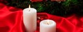 White candles on red satin burning on a dark background, banner Royalty Free Stock Photo